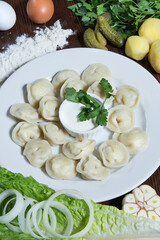 Dumplings on a wooden table with sour cream. Restaurant serving concept. Close-up.