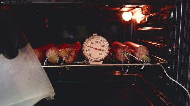 The cook pours boiling water into the tray of the electric oven. Homemade sausage cooking process