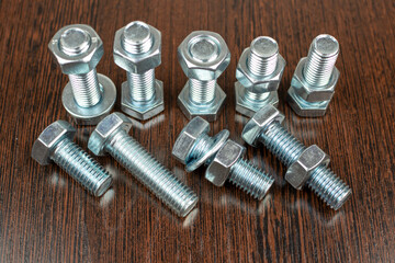 fasteners - bolts and nuts on a wooden table background