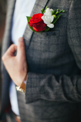 Wedding floristry. A boutonniere. The bride puts on the groom's boutonniere. Wedding Fashion 2021
