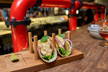 Traditional street mexican pork tacos with beef, tomatoes, avocado, chilli in yellow corn tortilla