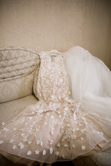 wedding dress of the bride on the bed in the room