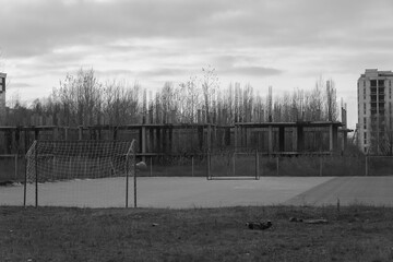 Abandoned soccer field among abandoned buildings. Black and white shoot.