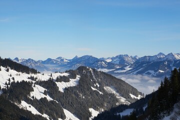 Winterliche Landschaft der schneebedeckten bayerischen Alpen vor blauem Himmel im Sonnelicht