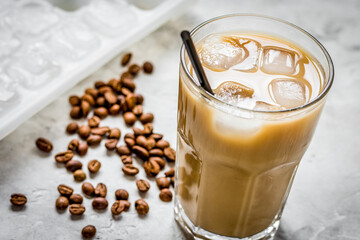 Ice coffee with milk and beans for lunch on stone background