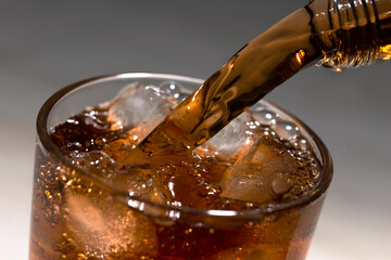 Pouring rum or brandy into glass with ice