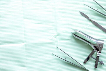 Naklejka premium instruments of gynecologist on green background top view mock up