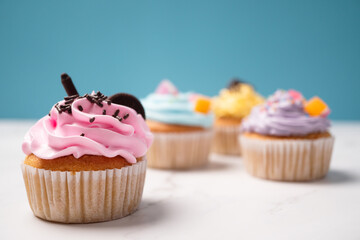 Delicious homemade cupcakes with Colorful cream and topping with candy and Chocolate Cookies. Homemade autumn holiday dessert