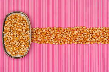 Abstract raw popcorn on pink background