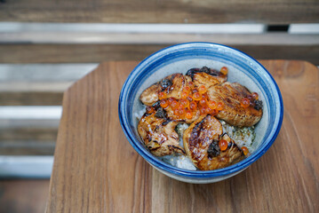 Foie gras don. A bowl of Japanese rice topped with grilled foie gras and salmon roe. (isolated)
