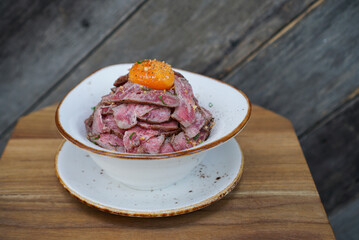 Wagyu Don. A bowl of Japanese rice topped with medium rare wagyu beef and egg yolk.