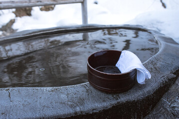 Bath bucket with towel at Japanese open air hot spring bath in snow　雪見露天風呂 桶とタオル