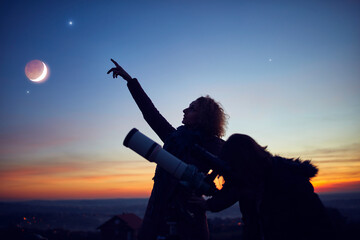 Mother and daughter observing stars, planets, Moon and night sky with astronomical telescope. - Powered by Adobe