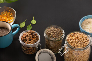 cannabis grains, soybeans, rice, nuts- healthy food ingredients in jars on a dark background