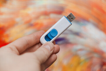 hand holds usb drive for computer on abstract background