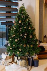 Fototapeta na wymiar Feast of Christmas. Beautifully decorated house with a Christmas tree ipodarkami underneath