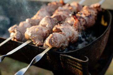 Marinated shashlik preparing on a barbecue grill over charcoal. Shashlik or Shish kebab popular in Eastern Europe. Shashlyk (skewered meat) was originally made of lamb. Roast Beef Kebabs On BBQ Grill.