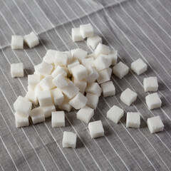 Organic White Sugar Cubes on cloth, side view.