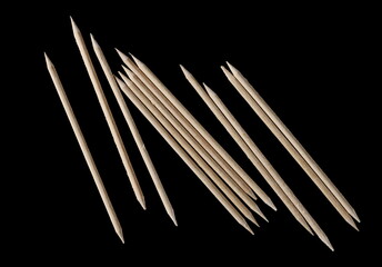 Wooden toothpicks pile isolated on black background