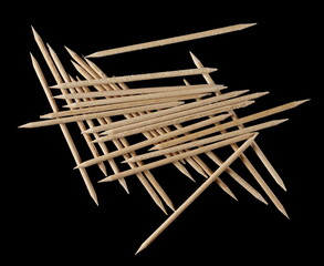 Wooden toothpicks pile isolated on black background