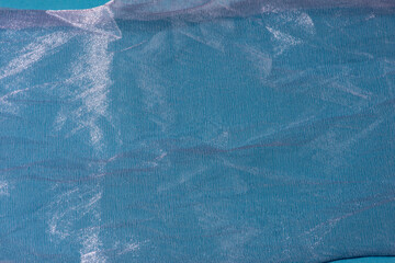 Blue shiny organza fabric close up. Abstract background.