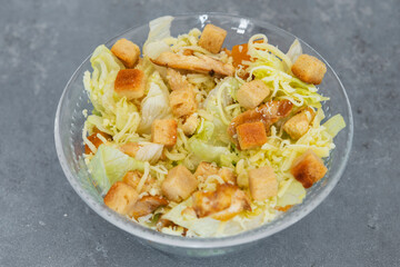 Caesar salad with toast, lettuce and grilled chicken breast and cheese