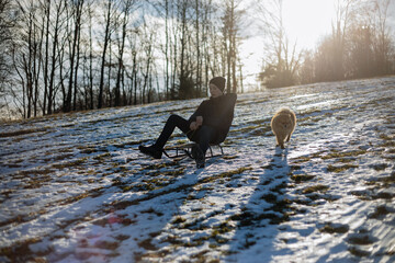 boy sledding down from the mountain,in winter the guy goes down the mountain on a sled