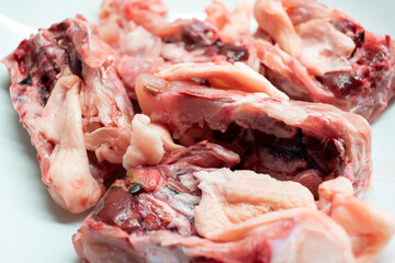 Raw uncooked chicken backs with skin and bone isolated on white close up shot