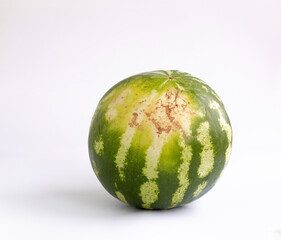 Whole watermelon isolated on white background. The part that was lying on the ground during...