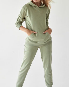 girl wears light green hoodie and pants. studio shot for sport clothing sale