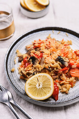 Arroz con verduras y azafran, spanish dish. Vegetarian risotto with  vegetables, champignons and saffron on beige linen tablecloth. Selective focus