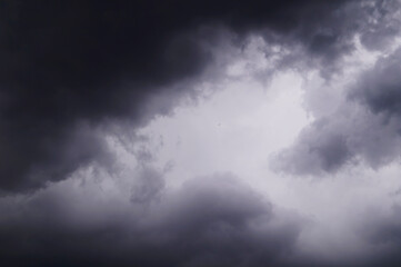 Naklejka na ściany i meble Dark gray storm clouds and a bird flying away into the distance.