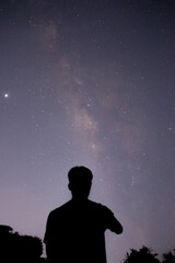 Fototapeta na wymiar the man standing in front of the sky with the beautiful milky way