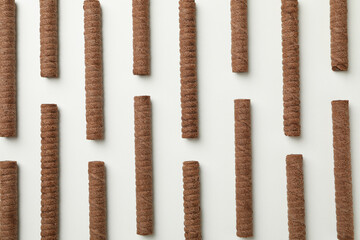 Flat lay with chocolate wafer rolls on white background