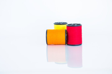 Red and orange thred spool on white background