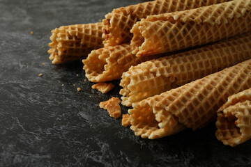 Wafer rolls with condensed milk on black smokey background