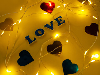 Valentine's Day Love glitter sign text on pastel yellow background hearts confetti, creative flatlay minimal concept. Greeting card top view social media sale banner design. Bright vebrant colors.