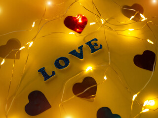 Valentine's Day Love glitter sign text on pastel yellow background hearts confetti, creative flatlay minimal concept. Greeting card top view social media sale banner design. Bright vebrant colors.