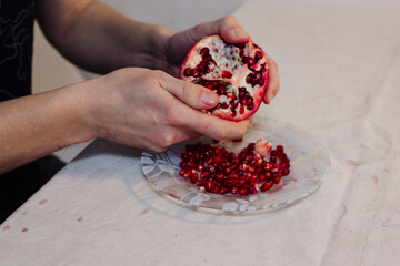 Man brushing pomegranate fruit with his hands