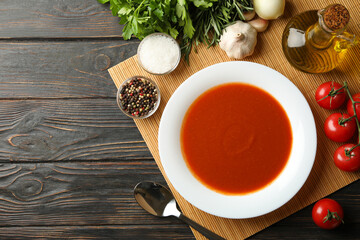 Concept of tasty dinner with tomato soup on wooden background