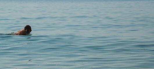 side view of a man swimming in the sea