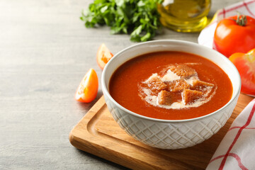 Concept of tasty food with tomato soup on gray background