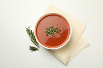 Bowl of tomato soup and towel on white background