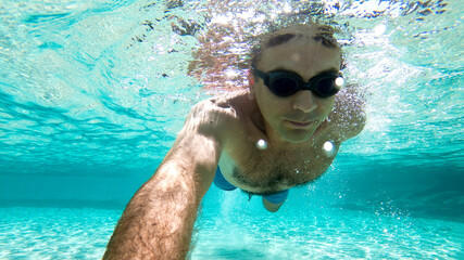 Caucasian man swimming under the water