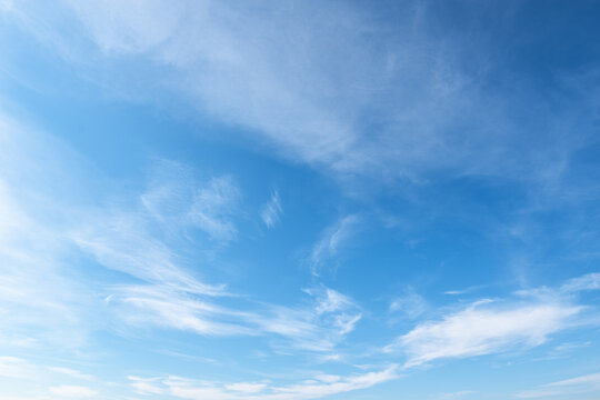 Background gradient blue sky with fluffy light white clouds. Natural background. Can be used to replace the sky in a photo