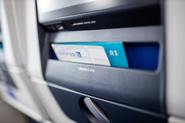 Gray and blue brochures in literature only compartment in airplane