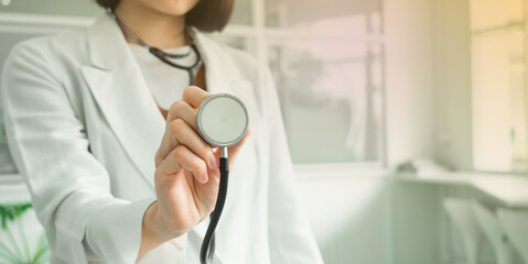 closeup hand of doctor holding stethoscope examining patient heart rate in hospital background.. healthcare, medical-care concept