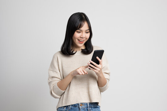 Pretty Young Asian Woman Using Smartphone Standing On Isolated W