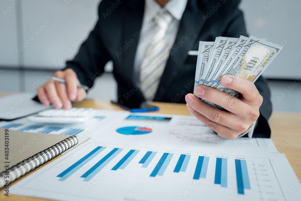 Wall mural close up of serious man hand checking bills and counting money at work from home office