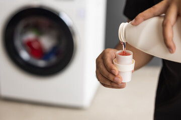 Pour some laundry detergent on the clothes and put it in the washing machine.